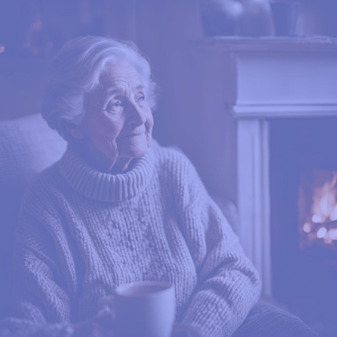 Elderly person sat by a fire